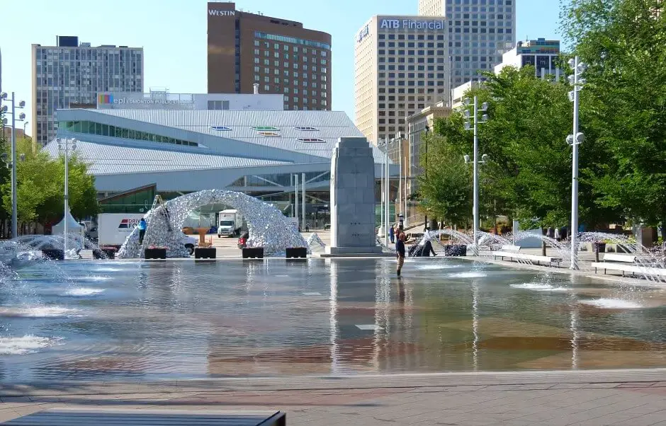 A city fountain in Edmonton surrounded by people walking