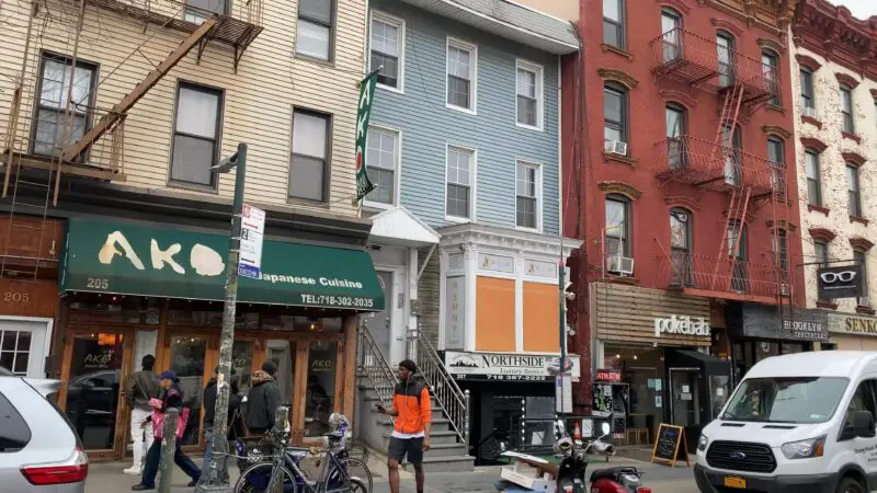 Street view of Williamsburg, Brooklyn showing restaurants, shops, and people walking by