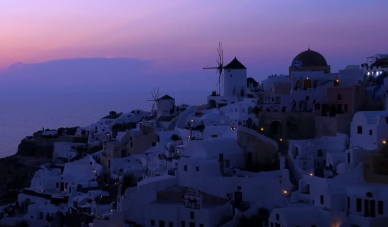 The Aegean Sea meets the horizon as the sun dips below the Santorini skyline