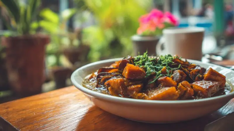 Close-up of a bowl of vegan vegetable stew served on a wooden table in a restaurant