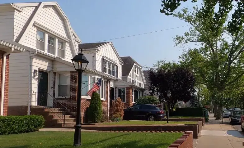 A quiet street, bathed in sunlight, lined with charming homes