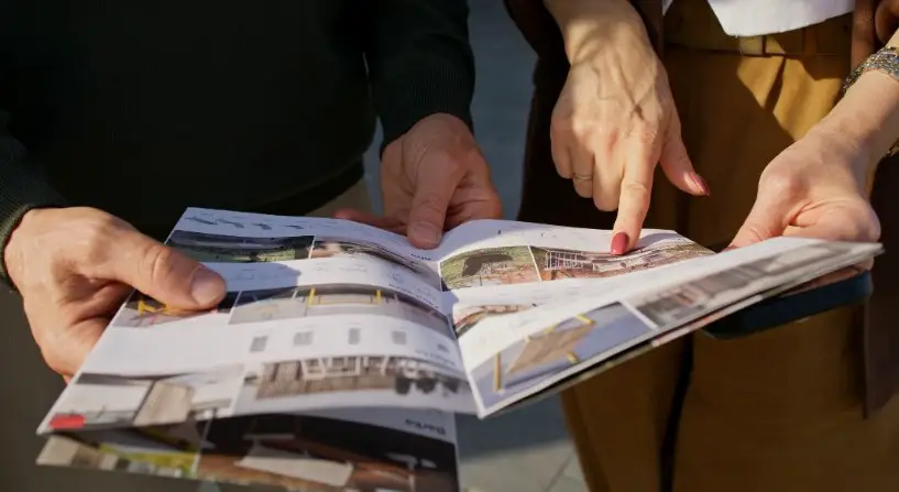 Hands carefully turning pages, filled with architectural visions