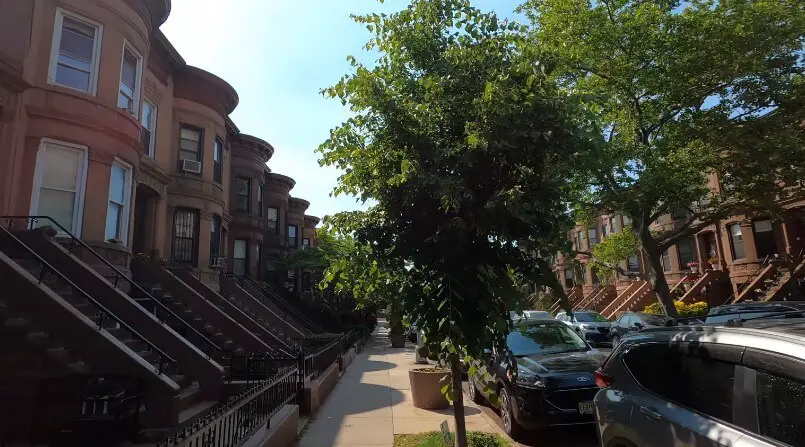 A row of classic brownstone townhouses lining a street in Brooklyn