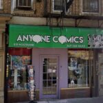 Anyone Comics storefront at the corner of a street, featuring colorful signage and a welcoming entrance