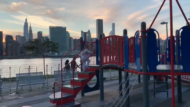 Hunter’s Point South Playground with red and blue play structures and a skyline view across the water