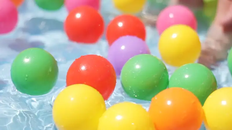 Colorful plastic balls floating in a pool for a kids birthday water play activity