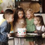 Kids gathered around a cake blowing out candles at a birthday celebration in Brooklyn